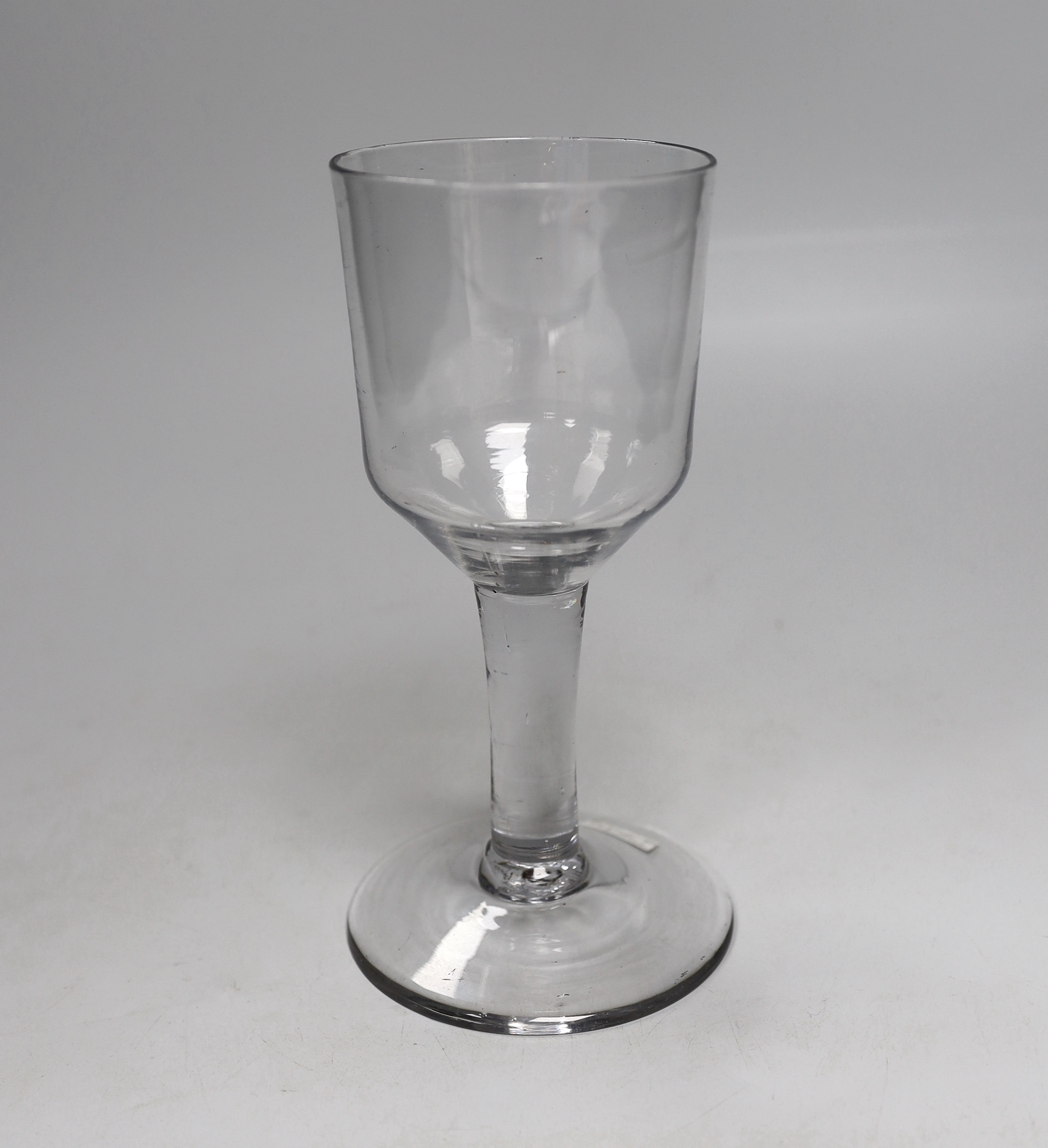 An English lead crystal goblet, c.1740-50, with blue tinge, the large ogee bowl is tool marked, the stem is plain and the conical foot has a rough pontil, 19cm high